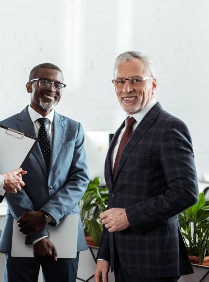 selective focus of cheerful businessmen and businesswoman standing in office